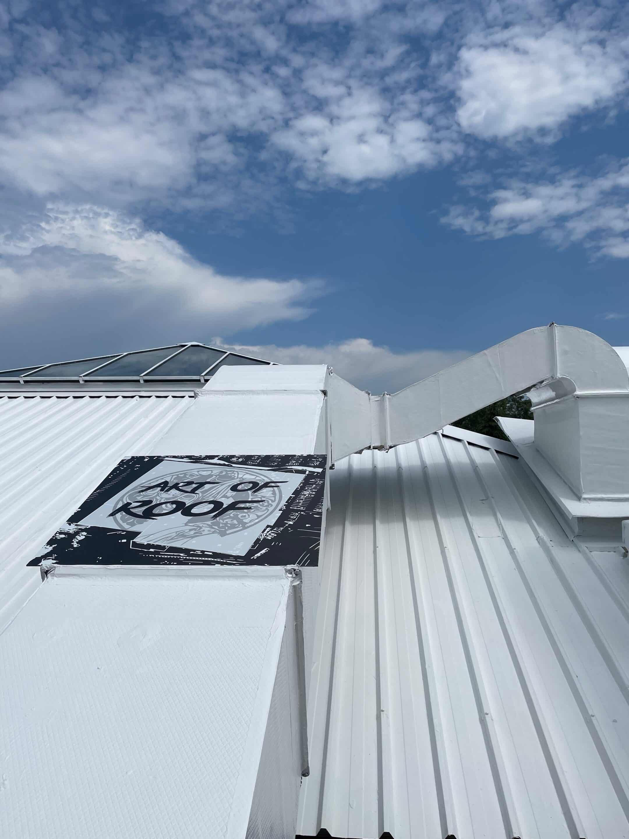 Toit en métal blanc avec fenêtre Vue d'un toit en métal blanc avec une fenêtre de toit et un ciel nuageux, idéal pour les projets de construction et de rénovation.