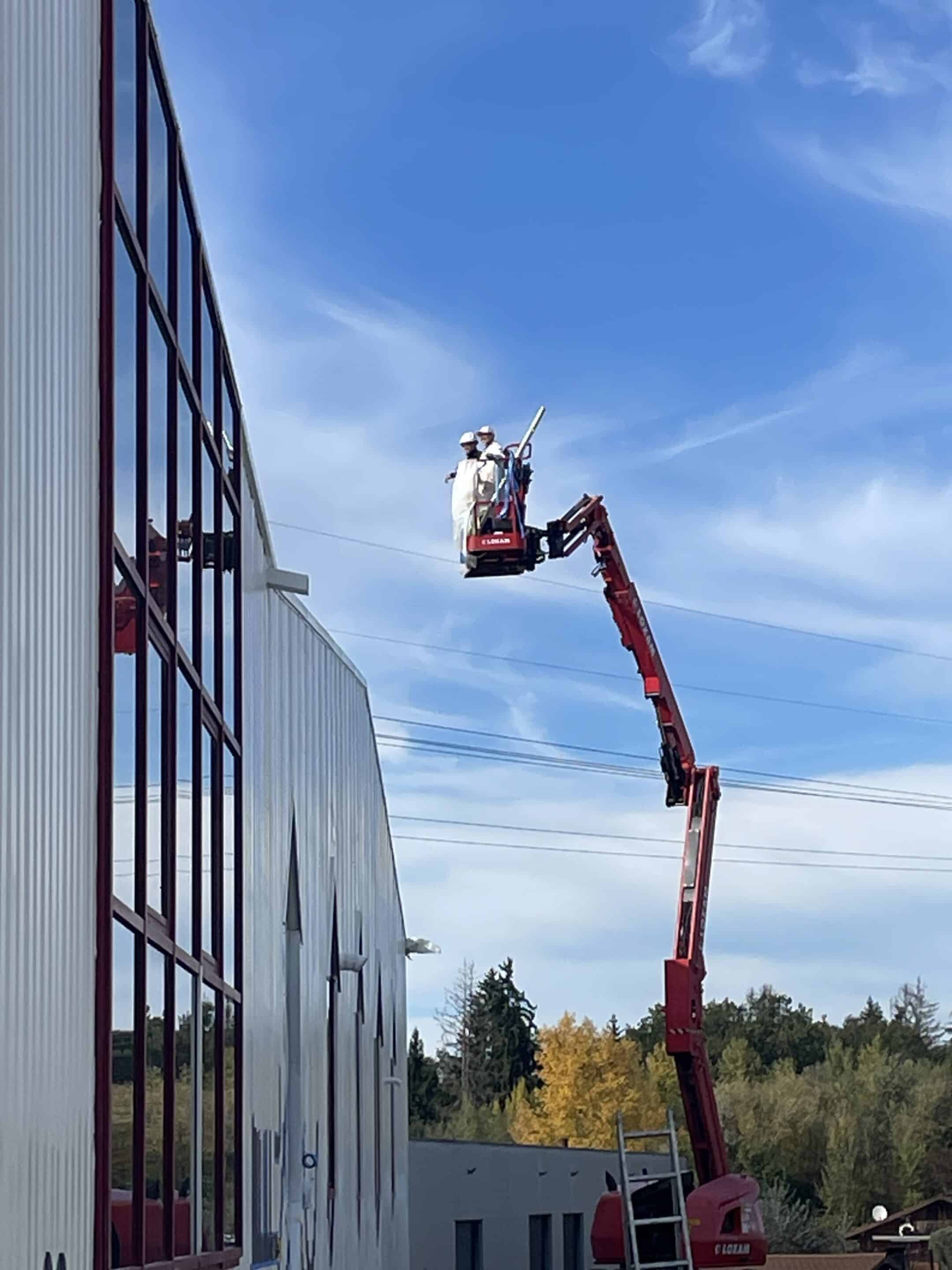 Nacelle élévatrice vue de dessous, avec un ciel nuageux en arrière-plan. Art of Roof
